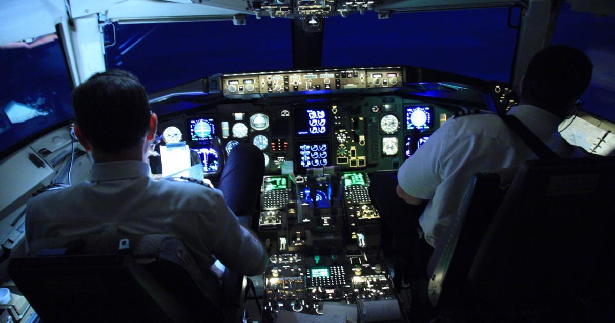 pilots in flight deck at night illuminated by electronic avionics