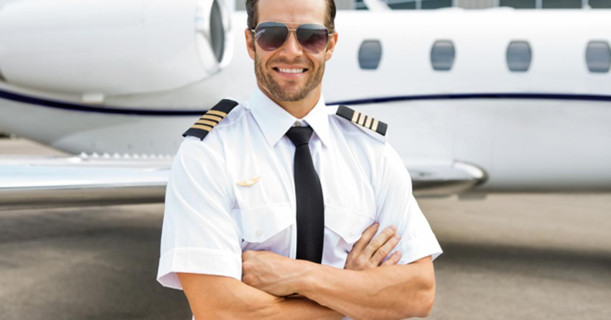 Business jet captain poses by wing