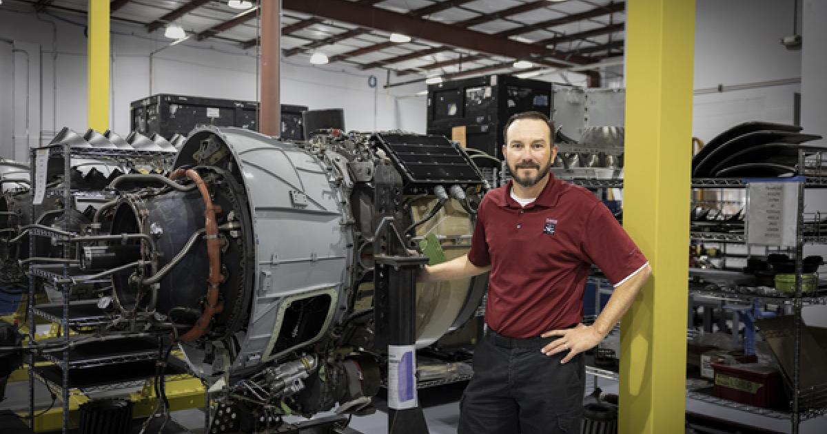 Shawn Schmitz, Duncan Aviation HTF7000 program manager poses by Honeywell HTF7000 engine in new shop