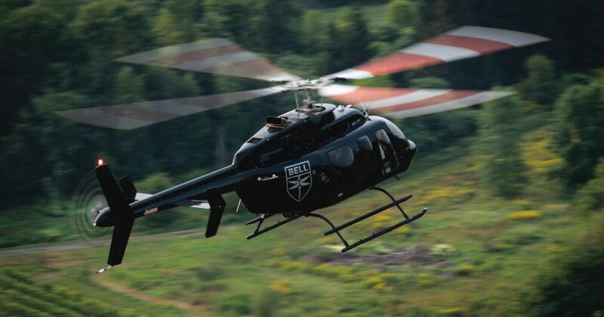 Bell 407GXi helicopter in flight over mountainous region