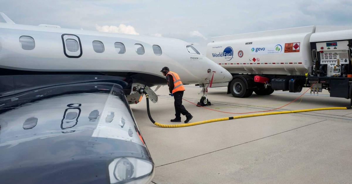 Line worker refueling business jet with sustainable aviation fuel from tanker truck