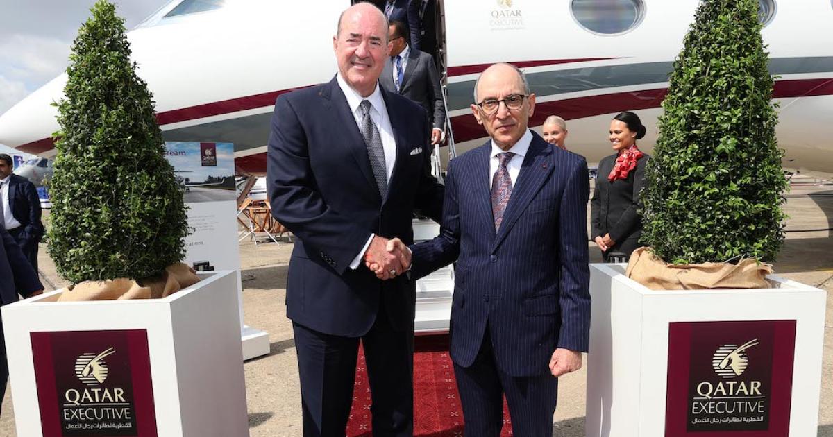 Gulfstream president Mark Burns (left) shakes hands with Qatar Airways CEO Akbar Al Baker at Paris Air Show static display with Gulfstream G700 business jet in background