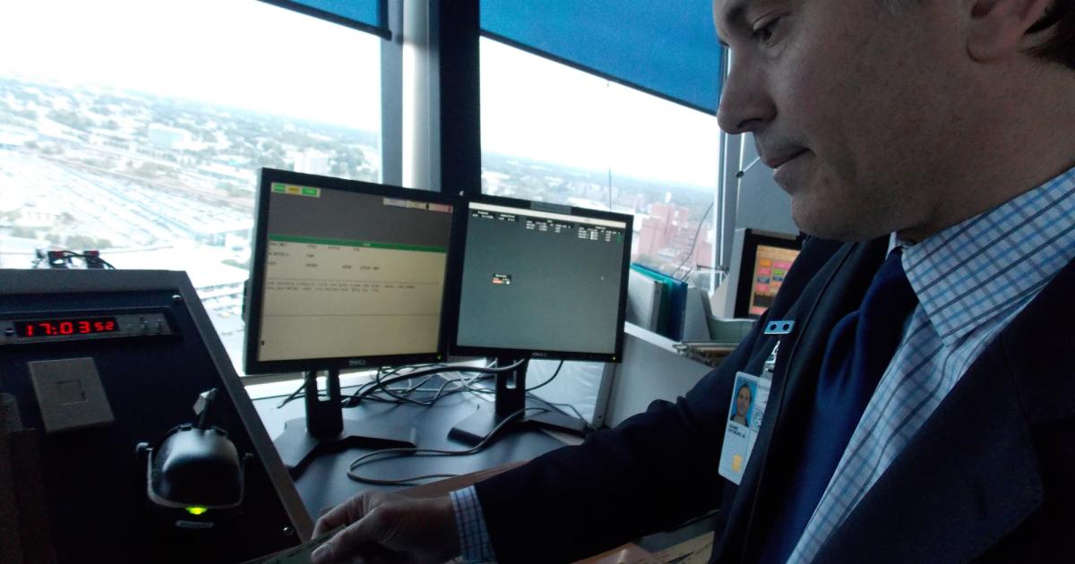 Newark-based air traffic controller Ray Adams demonstrates the data comm procedures in the airport’s control tower during a media event. (Photo: Curt Epstein)