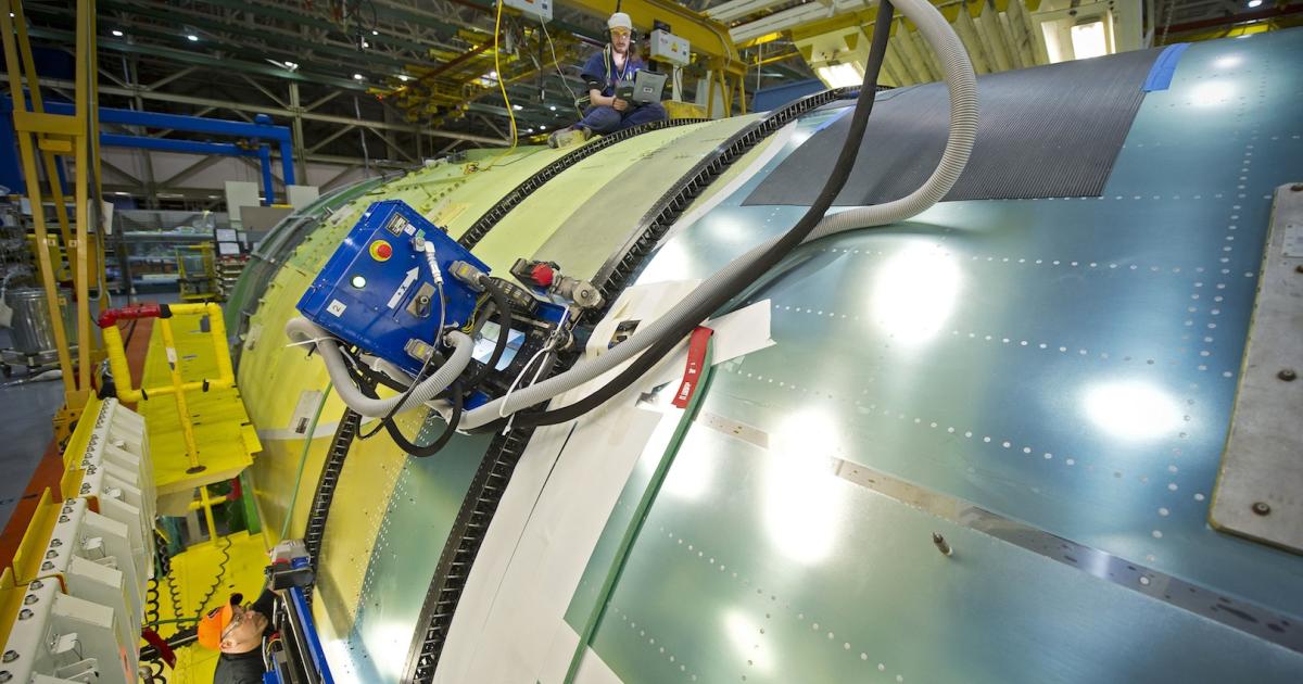 Boeing assembly mechanics work on mating 777 fuselage sections using automated Flex-Track equipment, which uses engineering data to drill and countersink holes around the circumference of the airplane. (Photo: Boeing)